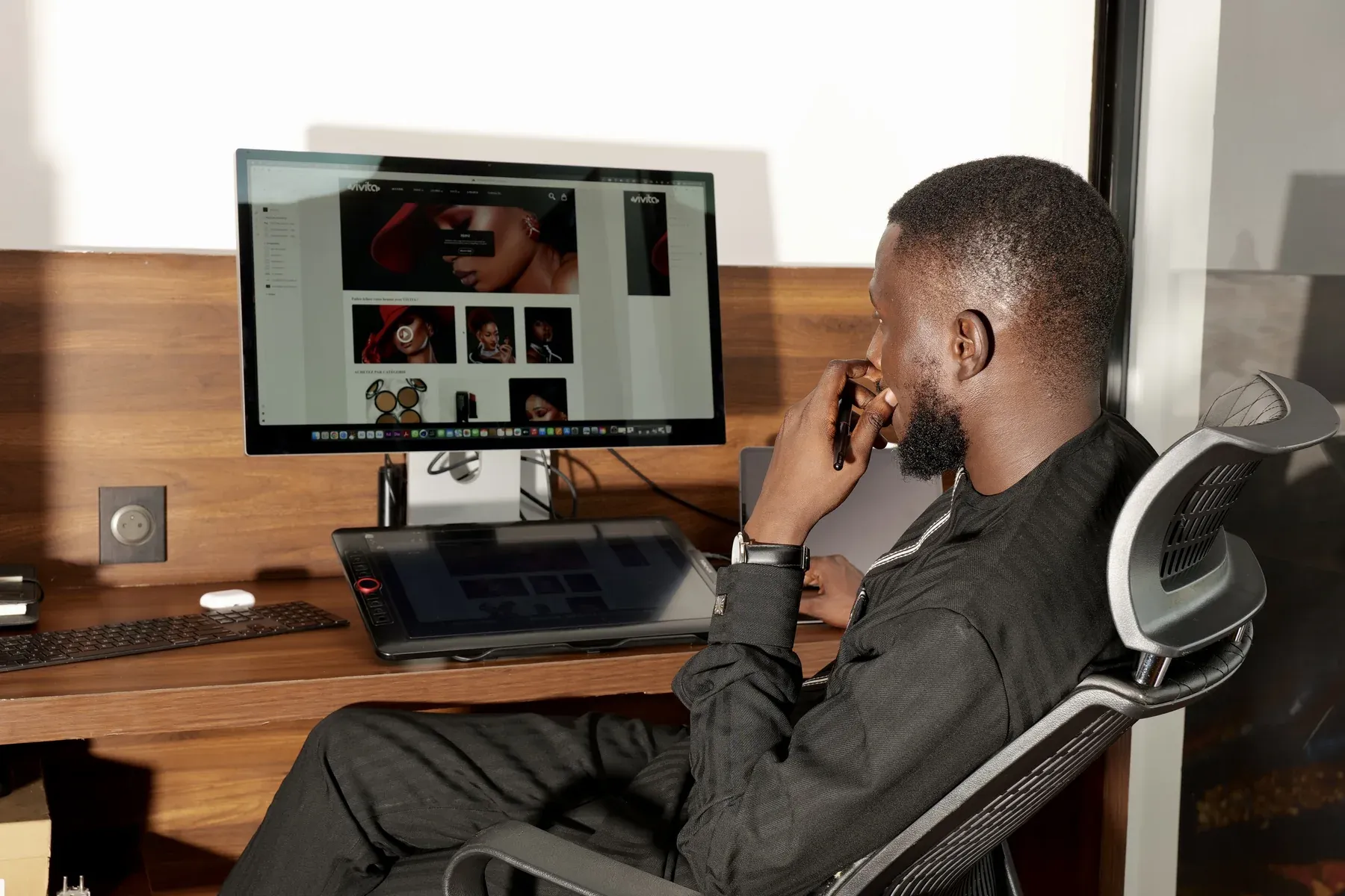 Ndiaga à son bureau, devant un grand écran